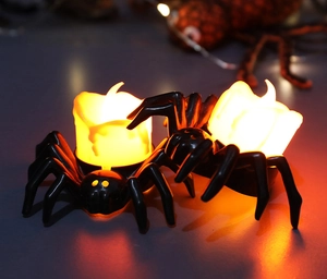 Close-up of LED spider candle lights with orange flame for Halloween decor