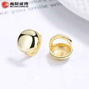 Close-up of golden S925 sterling silver ball earrings showing smooth polished surface