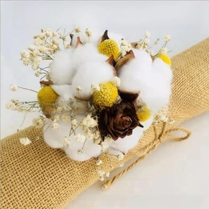 Detail of natural dried cotton bouquet with billy balls and baby's breath on burlap
