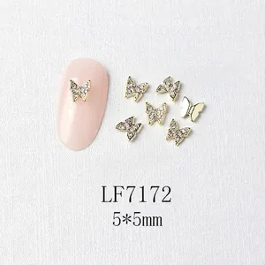 Macro view of 5x5mm mini golden metal butterfly nail charms with micro-pave crystals