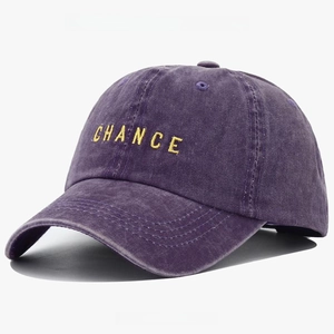 Detail of purple washed cotton baseball cap featuring yellow embroidered CHANCE letters