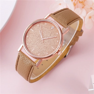 Dettaglio del quadrante stellato in oro rosa e cinturino in pelle marrone su orologio donna