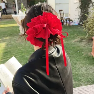 Red lace floral hair scrunchie with ribbons worn by a model in outdoor setting
