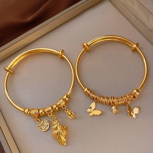 Close-up of gold plated copper bangles with traditional coin and butterfly charms
