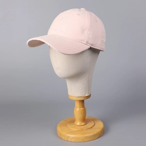 Détail d'une casquette rose avec bord en dentelle blanche et œillets de ventilation