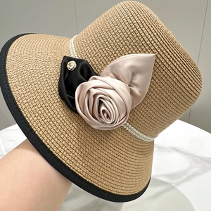 Détail d'un chapeau de paille avec texture tissée, perles et camélia en tissu élégant