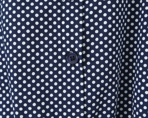 Detailed macro view of dark blue polka dot fabric texture and button sewing details