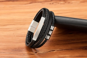 Macro detail of multi-layer braided leather bracelet with silver magnetic clasp and rings