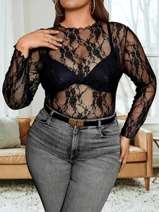 Detailed close-up of intricate black lace floral embroidery on long-sleeved sheer top