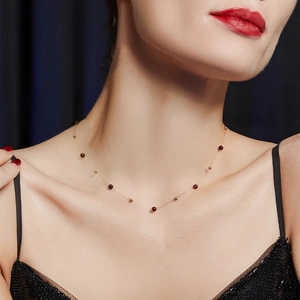 Collier vintage avec perles dorées et pierres rouges porté pour un look élégant