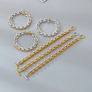 Close-up of assorted gold and silver stainless steel chain bracelets with OT toggle clasps