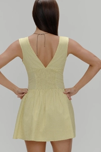 Détail du dos en V et de la coupe à la taille sur la robe jaune à pois pour femmes