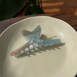 Détail de la pince à cheveux sirène dégradé bleu avec strass brillant sur plat céramique