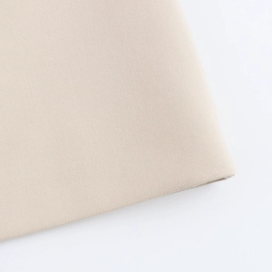 Close-up of beige twill fabric texture and material detail of the sleeveless dress