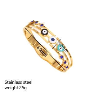 Vintage stainless steel evil eye bangle with blue rhinestones and gold finish