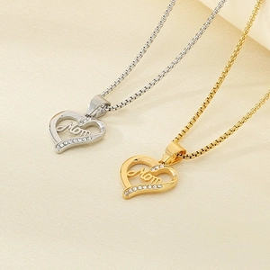 Close-up of gold and silver heart pendants with Mom engraving and sparkling rhinestones