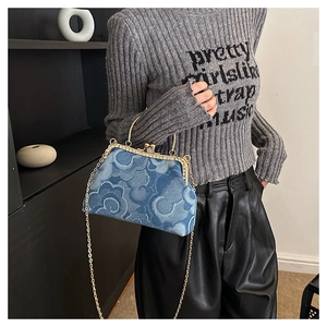 Detail of blue denim kiss-lock bag with auspicious cloud pattern and gold chain strap