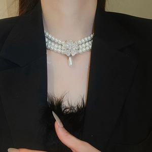 Detail of multi-layer pearl necklace with diamond clover and water drop pendant on model