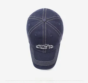 Top view of dark blue washed denim baseball cap with white mountain embroidery details