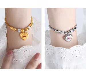 Close-up of heart-shaped evil eye pendants in gold and silver with zircon beads