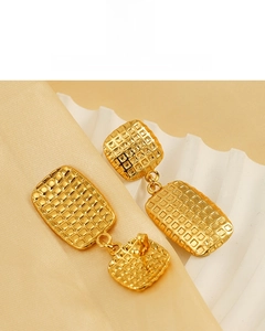 Detailed view of 18K gold plated checkered texture square drop earrings on silk