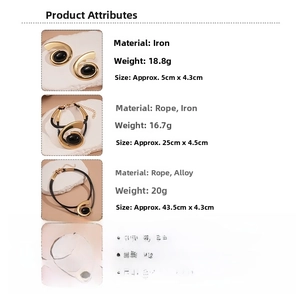Détails de trois colliers dorés vintage avec pierres noires sur des supports en pierre beige