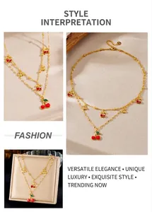 Detailed views of gold cherry pendant necklace with red enamel and double chain style