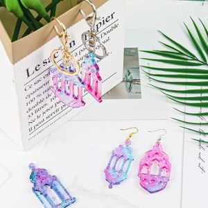 Detail of lantern-shaped glitter earrings and keychains on a decorative background