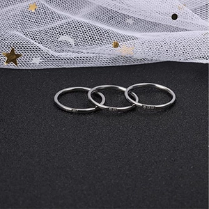 Macro detail of minimalist triple interlocking silver bands with a polished finish