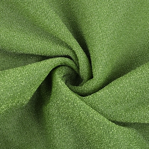Gros plan du tissu à paillettes vertes montrant la texture brillante et le drapé élégant
