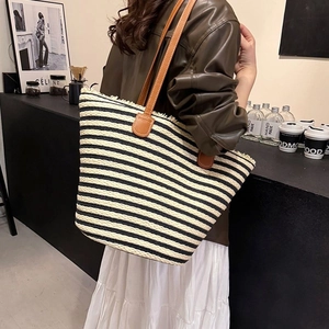 Striped straw tote bag with brown leather handles for summer beach vacations and daily commute