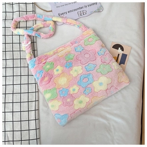 Detail of soft pink plush tote bag with colorful flower patterns on a white background