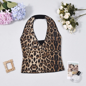 Flat lay of a leopard print sequin halter top with backless design on grey surface