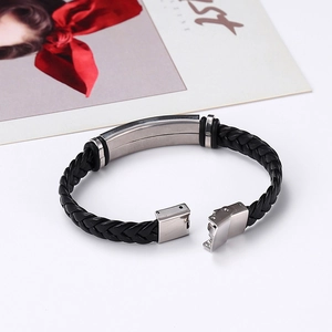 Detail of black braided leather bracelet with silver stainless steel clasp and plate