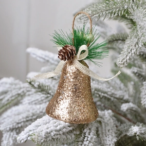 Cloche de Noël dorée scintillante avec pommes de pin et aiguilles sur sapin enneigé