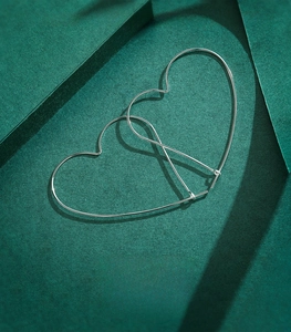 Detailed view of large minimalist heart-shaped earrings made of 925 sterling silver
