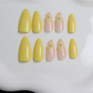 Press-on nail set featuring bright yellow and nude pink almond nails with 3D floral accents