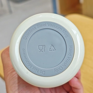 Detail view of the stainless steel vacuum mug base with care instructions and icons