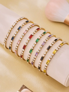 Detailed view of colorful square zircon bracelets on a beige display stand
