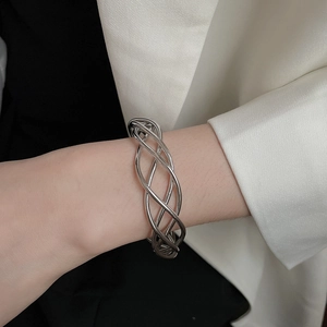 Close-up of silver hollow woven bracelet on model wrist with modern minimalist style