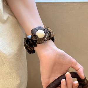 Vintage ethnic style coconut shell and wooden bead elastic bracelet shown on a wrist