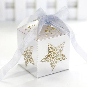 Macro detail of laser-cut star and heart patterns on a white festive candy gift box