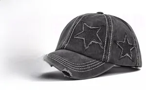 Detail of vintage washed black denim baseball cap with star patches and distressed seams