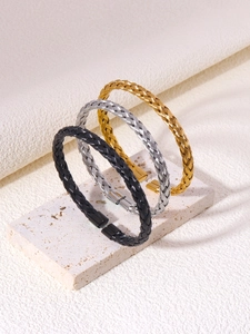 Detailed view of woven metal wire texture on a minimalist three-piece cuff bracelet set