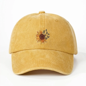 Detailed close-up of yellow baseball cap featuring sunflower and butterfly embroidery