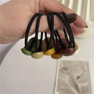 Close-up of elastic hair ties with glossy resin beads in various Morandi colors