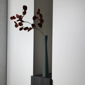 Vaso in ceramica verde spazzolato moderno e minimalista con eleganti foglie rosse secche