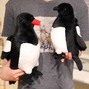 Realistic magpie plush toys set with black and white fur shown in a pair by hand