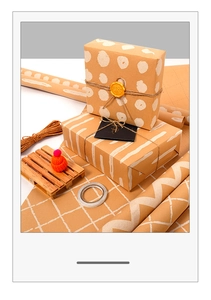 Brown kraft gift wrapping paper with white polka dots, twine, and wax seal detail