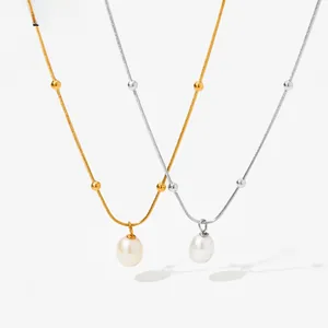 Close-up of minimalist pearl pendant necklaces in gold and silver with snake bone chain